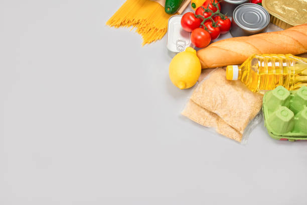 istock Flat lay composition with food donations on grey background with copyspace - pasta, fresh vegatables, canned food, baguette, cooking oil. Food donations and food bank concept 1291573517