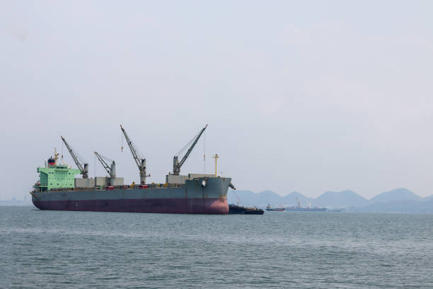 istock A ship carrying goods at sea With mountains in the background 1291573971