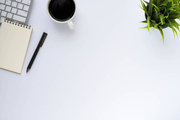 istock White office desk table with keyboard, notebook and coffee cup with equipment other office supplies. Business and finance concept. Workplace, Flat lay with blank copy space. Top view 1291574198