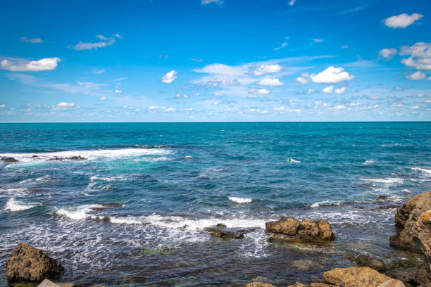 istock Rocks and sea with cloudy sky 1291574557