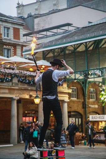 Young performer man performing his show with fire at Christmas in Covent Garden, London, United Kingdom