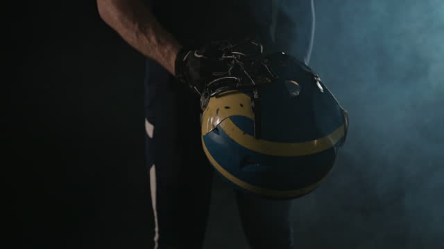 American football sportsman player holding a helmet