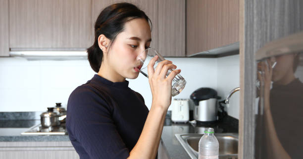 istock Woman Drinking Water At Home 1291582770