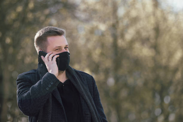 istock Masked man walking in the park 1291586092