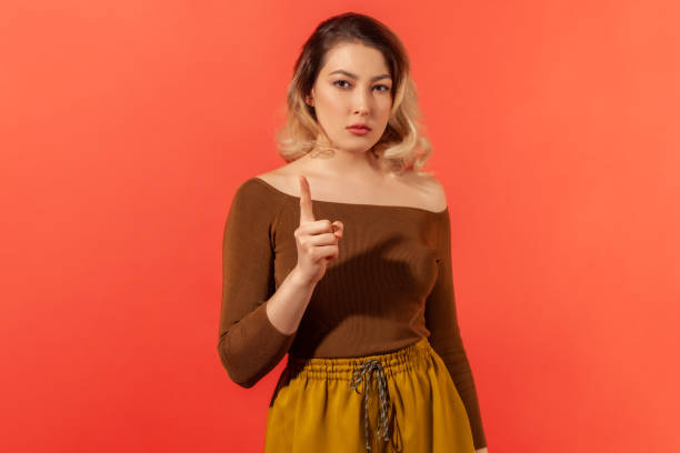 istock Lady boss or teacher looking at the camera with serious face and finger warning 1291589416