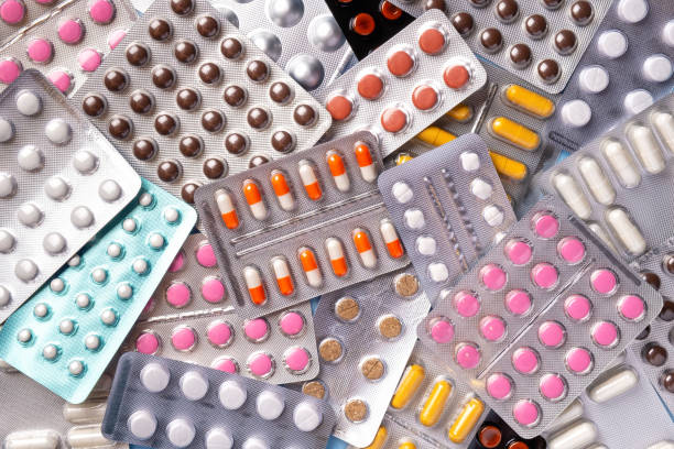 um monte de pílulas de cores diferentes em pacote de bolhas, close-up. comprimidos de farmácia. - blister pack pill medicine healthcare and medicine - fotografias e filmes do acervo