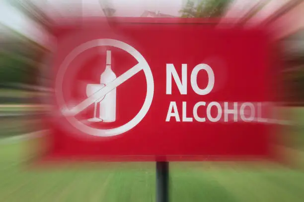 Close-up of the no alcohol sign in motion blur in the park near residential area.