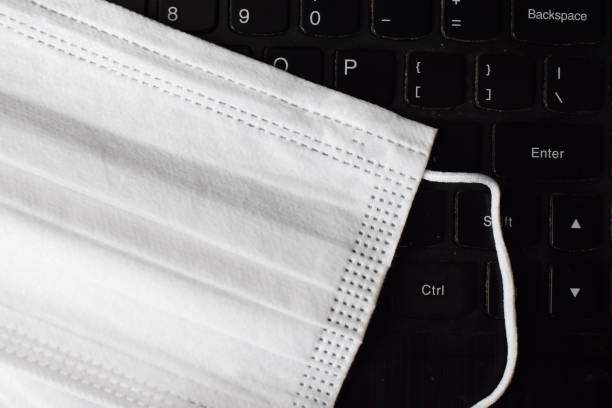 istock White Medical Face Mask On Laptop Keyboard 1291592131