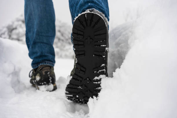 istock Man with jeans trekking on snowy path 1291592572