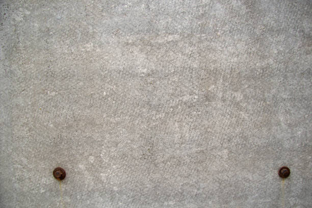 istock Grey rough background. at the bottom you can see two rusty screws, with a flat slate attached to a wooden board. 1291592591