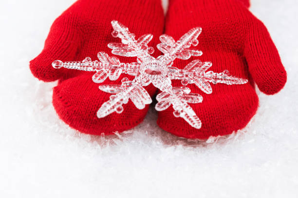 istock Christmas snowflake on red knitted mittens 1291596592