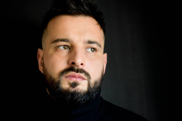 Portrait of man next to a black wall