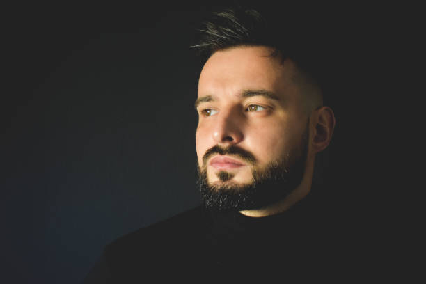 istock Portrait of man next to a black wall 1291598924