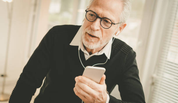 istock Businessman using earphones during conversation on mobile phone 1291600069