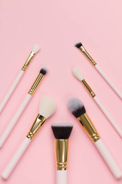 istock Set of makeup brushes in different sizes on a pink background in geometric order. 1291600540