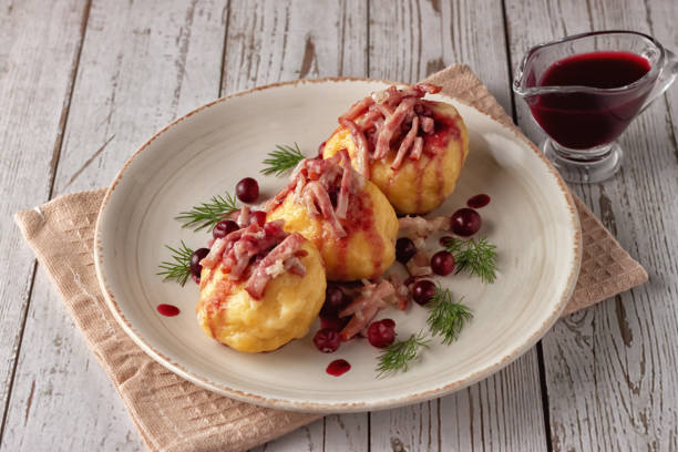 istock Swedish potato dumplings with cranberry sauce on a light background 1291602845