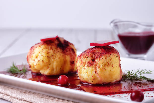 istock Swedish potato dumplings with cranberry sauce on a light background 1291602861
