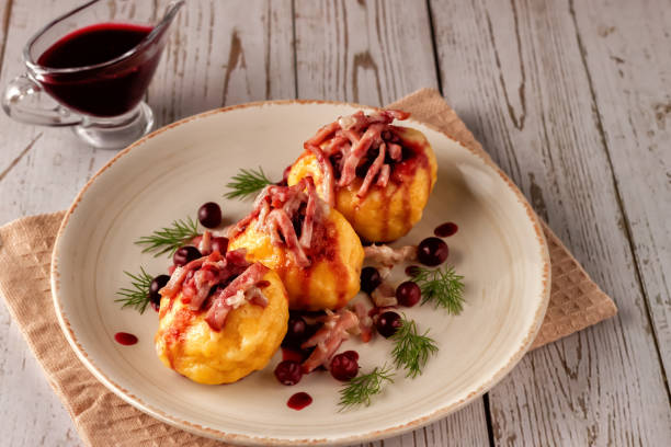 istock Swedish potato dumplings with cranberry sauce on a light background 1291602864