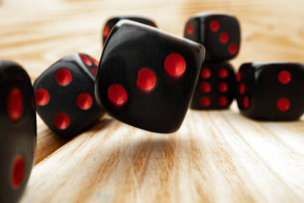 istock Macro of black tossed dice on wooden background 1291604932