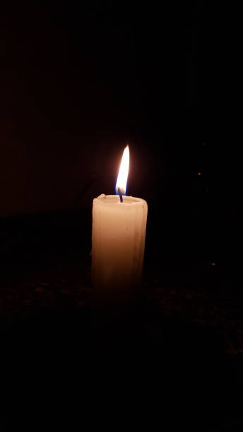 istock Flame of a candle on the black background 1291606131