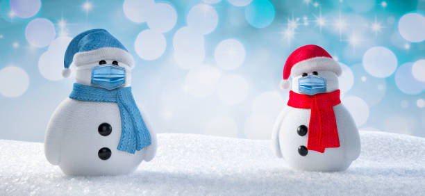 istock Two Snowman with face masks 1291606595