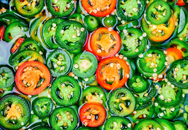 Raw green hot mexican peppers jalapeno Spanish tapas, sliced preparation for canning. Flat lay, natural food fermentation idea stock photo