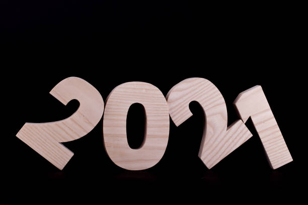 istock 2021 year wooden numbers tilted on black 1291609695
