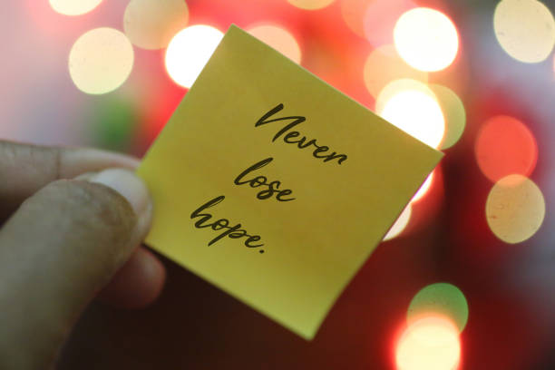 istock Positive notes on yellow paper in hand. Never lose hope. 1291611128