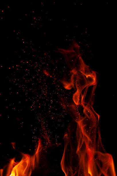istock Fiery flame with sparks on a black background. Texture (element) for barbecue or cooking 1291611193