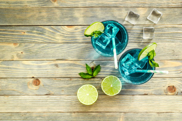 istock Blue beverage, iced alcohol cocktail drink with lime and mint, top view 1291611396