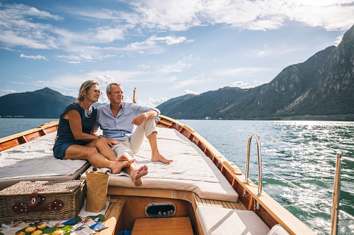 Pareja madura relajarse en velero moviéndose a través del lago Lugano photo