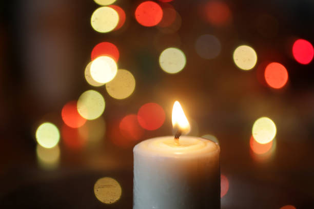 istock White candle light in the night on colorful bokeh light background. 1291612656
