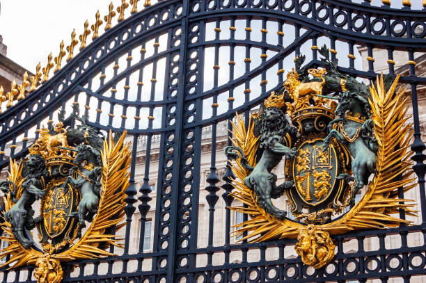 Golden emblem of the Royal family on the gate of the Buckingham Palace London, United Kingdom - September 14, 2017: Golden emblem of the Royal family on the gate of the Buckingham Palace british royalty photos stock pictures, royalty-free photos & images