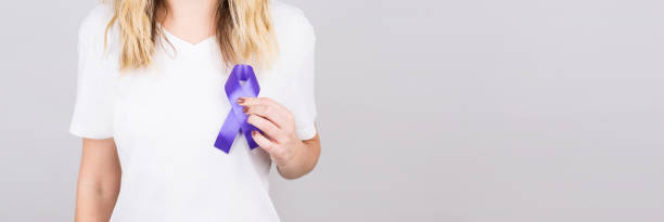 женщина, держащая фиолетовую ленту на белом фоне, крупным планом с пространством для текста. болезнь альцгеймера, рак поджелудочной железы, - purple ribbon alzheimers disease alertness стоковые фото и изображения