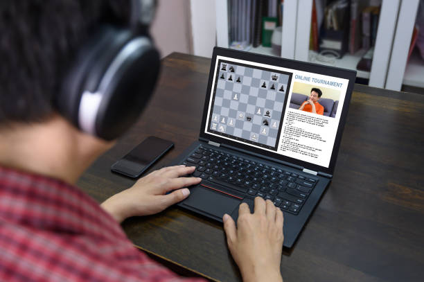 Mid Asian adult participating and competing in online chess tournament Playing chess online anytime anywhere and it’s the ability to play with opponents from all over the world with different skill levels across various time zones. 5G & Wireless Technology, Home Hobbies & Self Development, Healthier, Longer and Better Lives Concepts. computer chess stock pictures, royalty-free photos & images