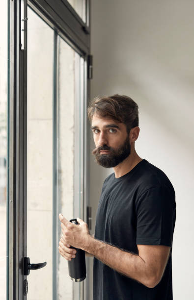 istock Man looking at camera with a water bottle in his hand 1291621065