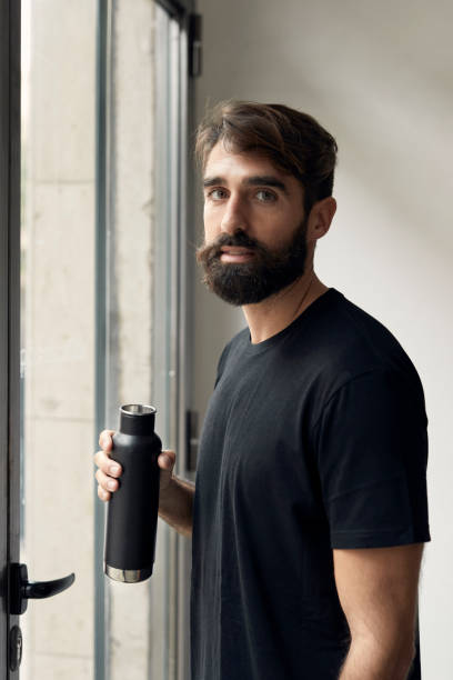 Sportsperson looking at camera with a water bottle in his hand