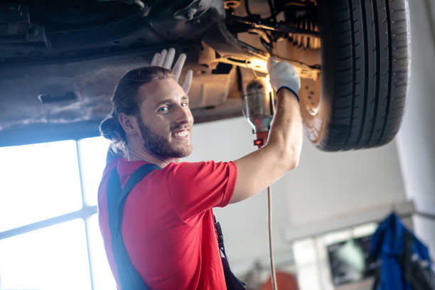 istock Joyful man in overalls repairing car 1291621786