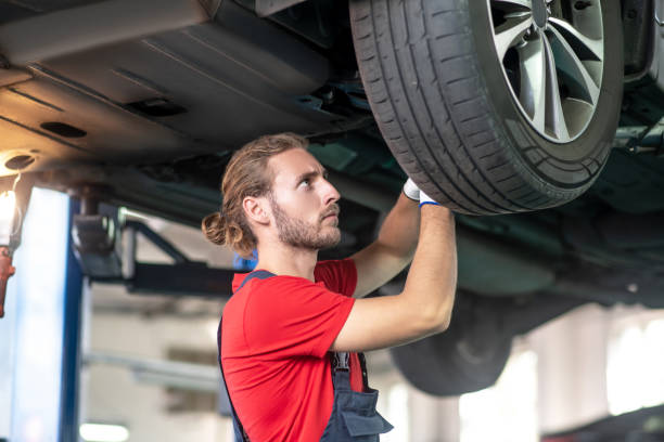 istock Concerned man in uniform repairing a car 1291621791