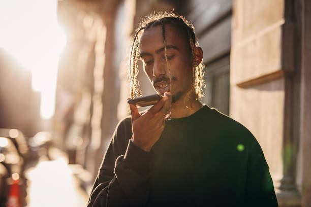 istock Young rapper using smart phone for voice messaging outdoors in the city 1291622586