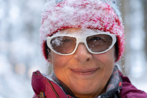 istock ageless senior woman in winter forest, standing under falling snow 1291622641