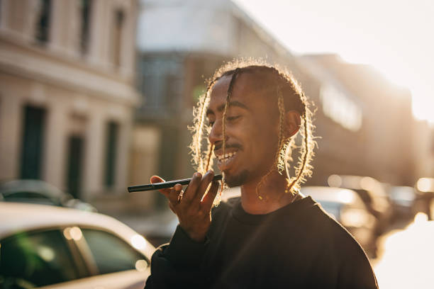istock Young rapper using mobile phone for voice messaging outdoors in the city 1291622758
