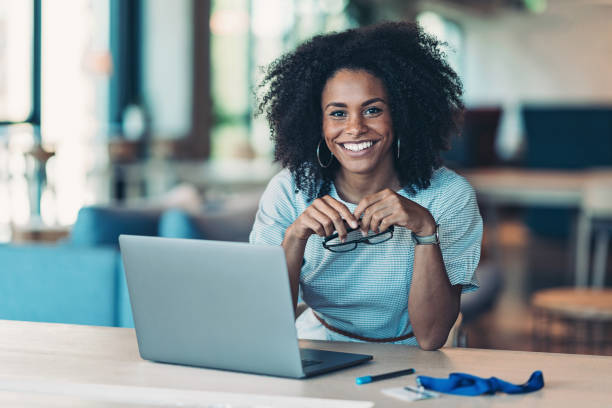 jeune femme d’affaires dans un bureau moderne - african ethnicity women laptop computer photos et images de collection