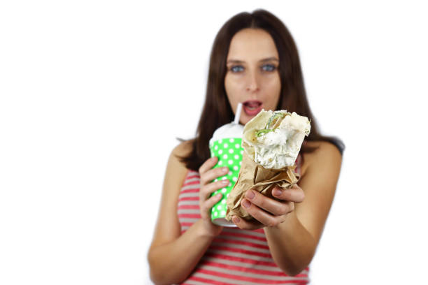 istock Attractive girl eats hot dog and drinks juice 1291624194