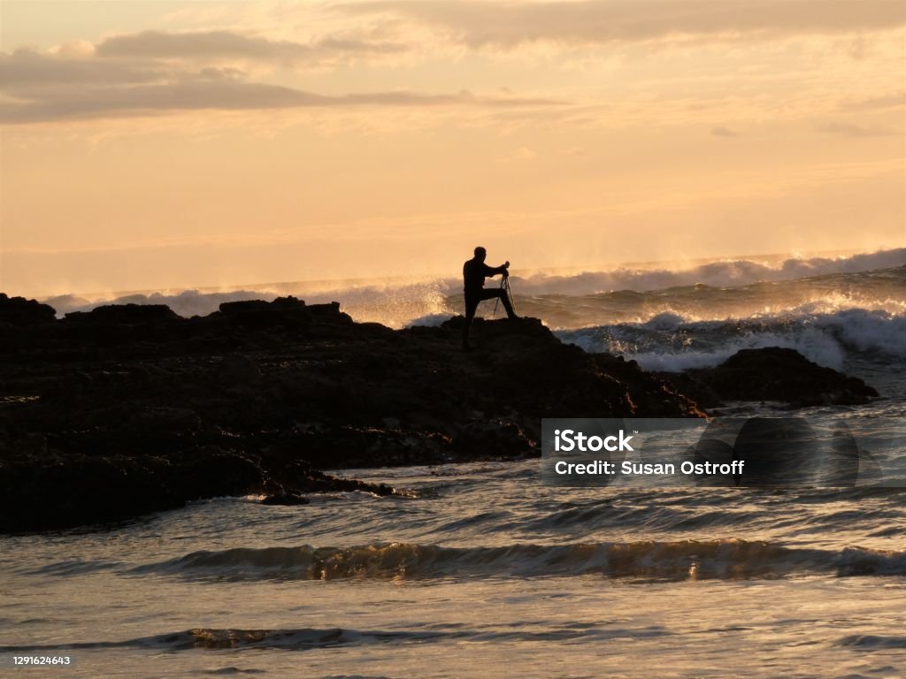 Bethells Beach, New Zealand Photographer on Bethells Beach photographing the surf. Bethells Beach Stock Photo