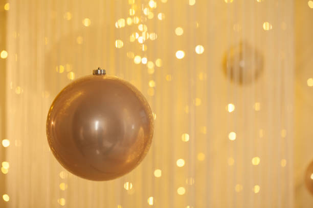 Golden decoration bauble on abstract bokeh glitter light background
