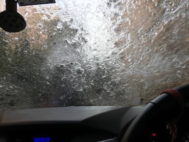 istock Splashing water in car windshield, View from the inside of car 1291625705