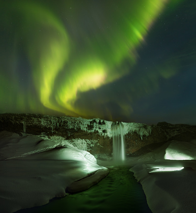 Beautiful Northern lights over Seljalandsfoss waterfall, Iceland. Winter time on most popular place.