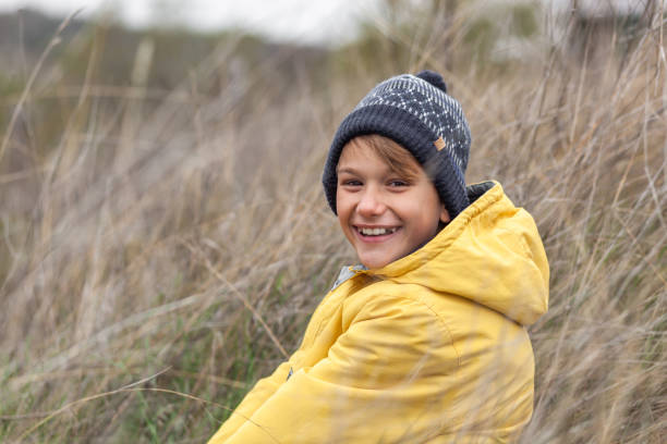 istock Happy little boy relaxing in tall grass in a meadow. 1291628053