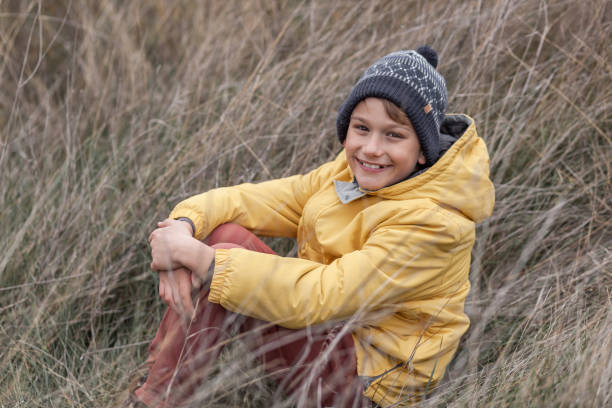 istock Happy boy enjoying in tall grass in a meadow. 1291628703